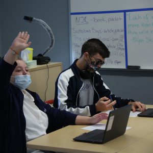 Scholar raising hand in classroom